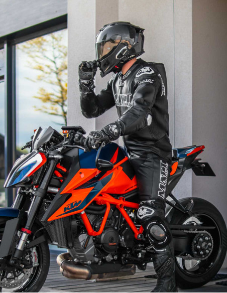 combinaison noir pour piste et route, normé AAA avec airbag intégré HELITE sur une ktm orange